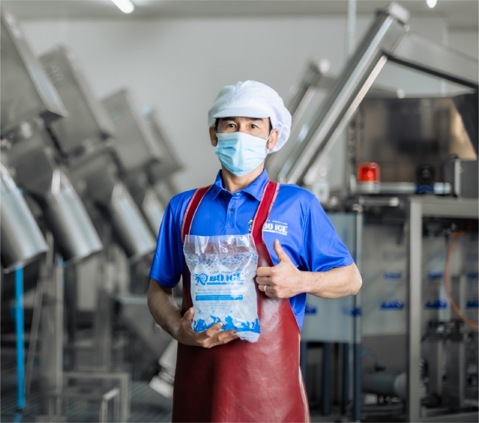 Bo Ice Factory team member holding a bag of ice inside the factory